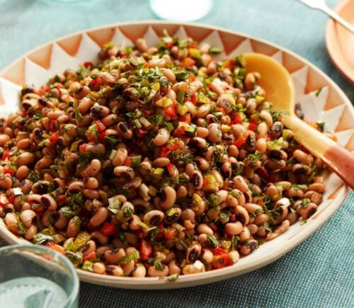 a plate of black-eyed bean salad with onion, bell pepper, and cornichons