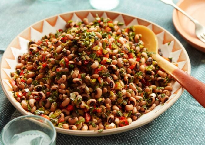 a plate of black-eyed bean salad with onion, bell pepper, and cornichons