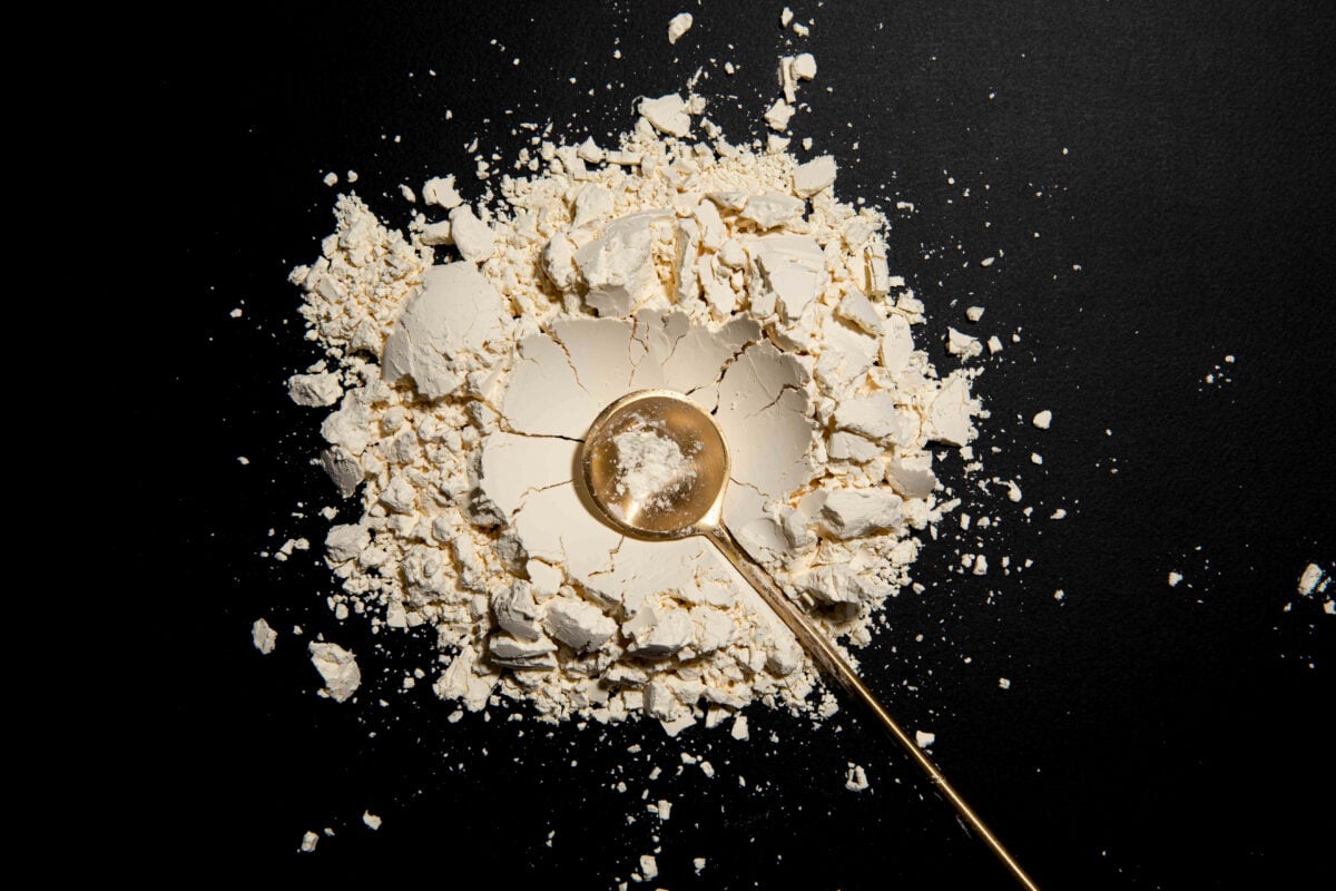 Photo shows a scoop of Eat Just's new vegan protein powder on a black tabletop