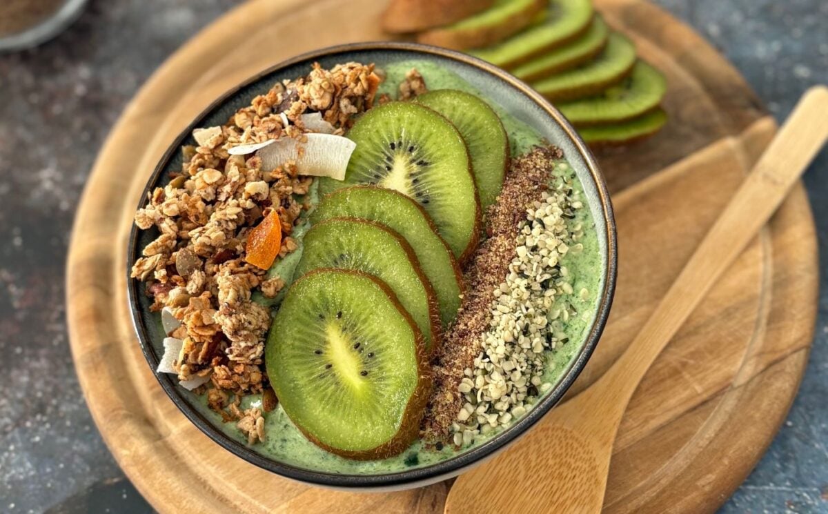 A green smoothie bowl with fruit and granola toppings, a healthy plant-based breakfast