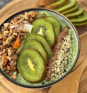 A green smoothie bowl with fruit and granola toppings, a healthy plant-based breakfast