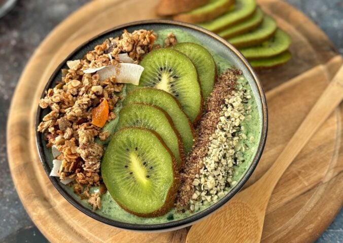 A green smoothie bowl with fruit and granola toppings, a healthy plant-based breakfast
