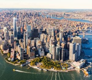 Photo shows an aerial view of lower Manhattan and the rest of the New York City skyline