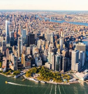 Photo shows an aerial view of lower Manhattan and the rest of the New York City skyline