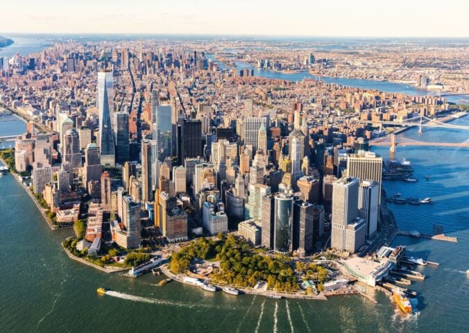Photo shows an aerial view of lower Manhattan and the rest of the New York City skyline