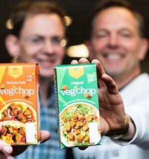 Photo shows Oh So Wholesome founders Jason Gibb and Simon Day holding up packets of their flagship “Veg’chop" product