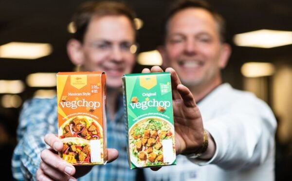 Photo shows Oh So Wholesome founders Jason Gibb and Simon Day holding up packets of their flagship “Veg’chop" product