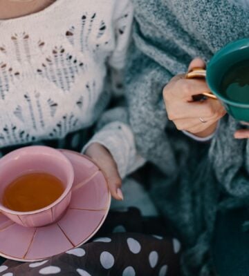 Photo shows two women drinking cups of herbal tea