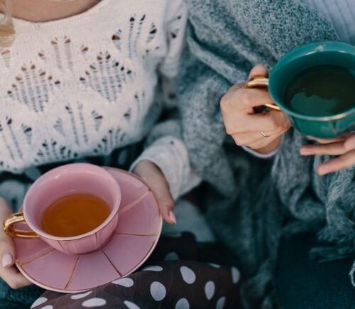 Photo shows two women drinking cups of herbal tea