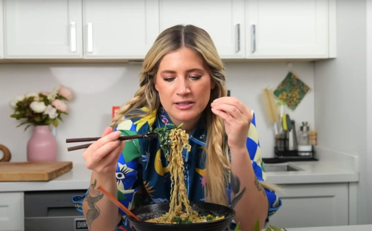 Candice Hutchings eats a bowl of ramen in a video featuring realistic high protein meals that she eats in a day