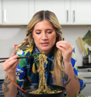 Candice Hutchings eats a bowl of ramen in a video featuring realistic high protein meals that she eats in a day