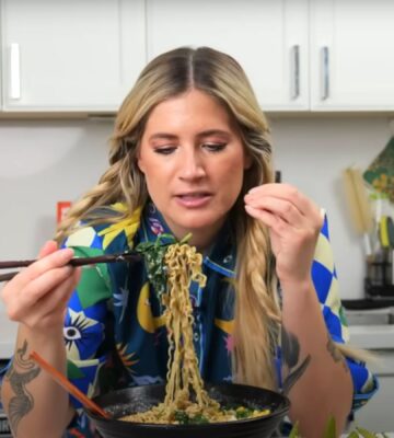 Candice Hutchings eats a bowl of ramen in a video featuring realistic high protein meals that she eats in a day