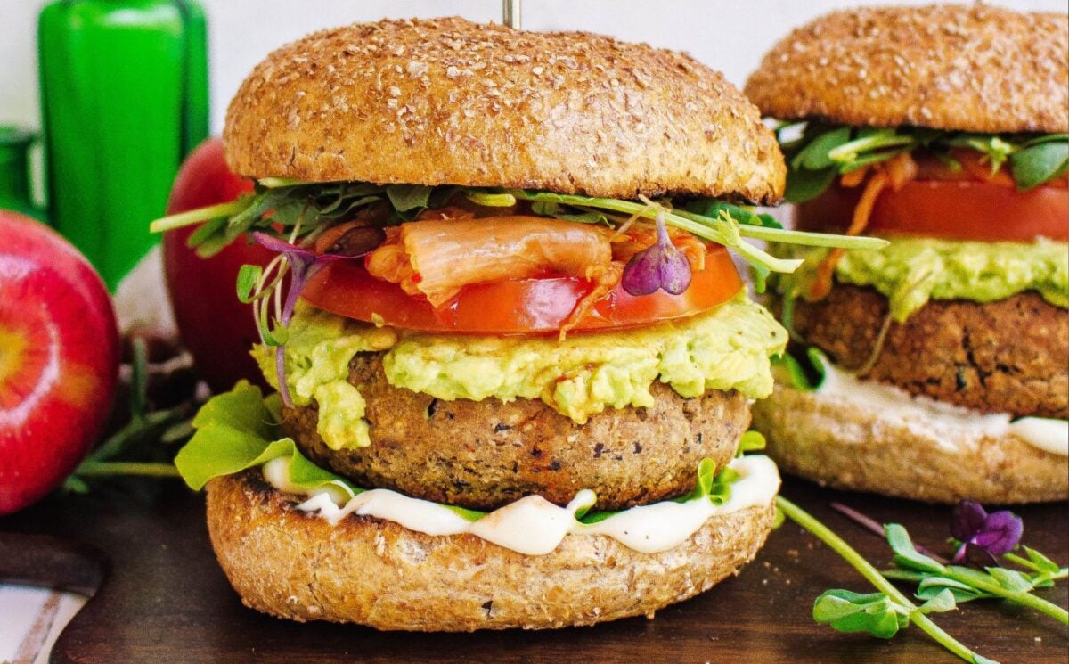 Two tempeh and apple burgers with tomato and avocado