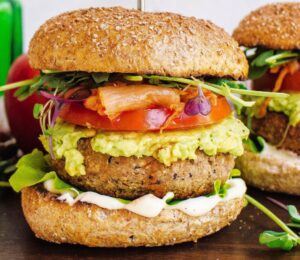 Two tempeh and apple burgers with tomato and avocado