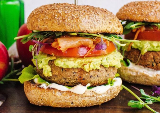 Two tempeh and apple burgers with tomato and avocado