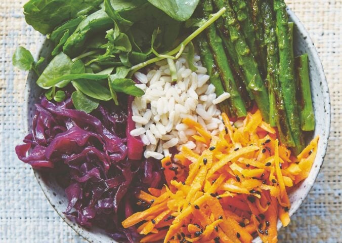 vegan bibimbap with cabbage, white rice, shallots, sweet and sour dressing, and asparagus
