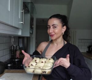 a picture of Leila Hannoun holding hot cross buns for her vegan café