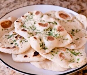 A plate full of homemade vegan naan recipe with dairy-free garlic butter