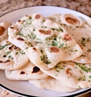 A plate full of homemade vegan naan recipe with dairy-free garlic butter