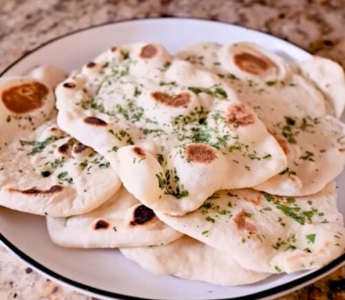 A plate full of homemade vegan naan recipe with dairy-free garlic butter