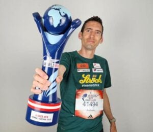Vegan runner Andreas Vojta holding a trophy for Wings for Life World Run