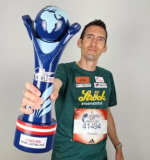 Vegan runner Andreas Vojta holding a trophy for Wings for Life World Run