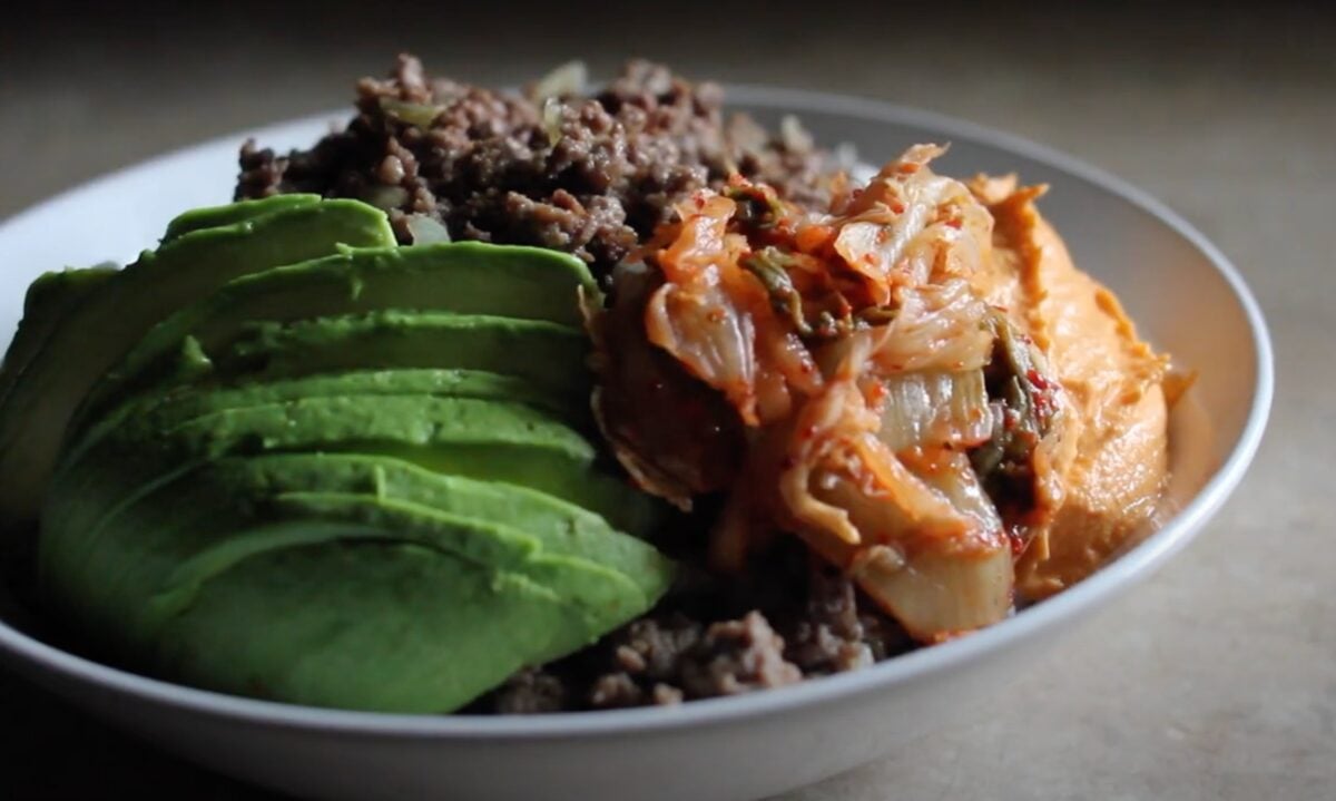 A rice bowl featuring Impossible meat, kimchi, and avocado - a meal eaten as part of a vegan runner diet