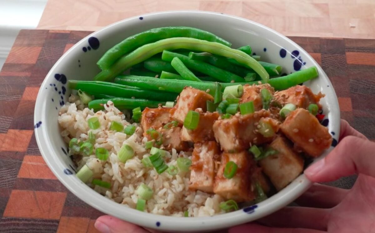 a bowl of sticky tofu, green beans, and brown rice as a vegan weightlifter meal