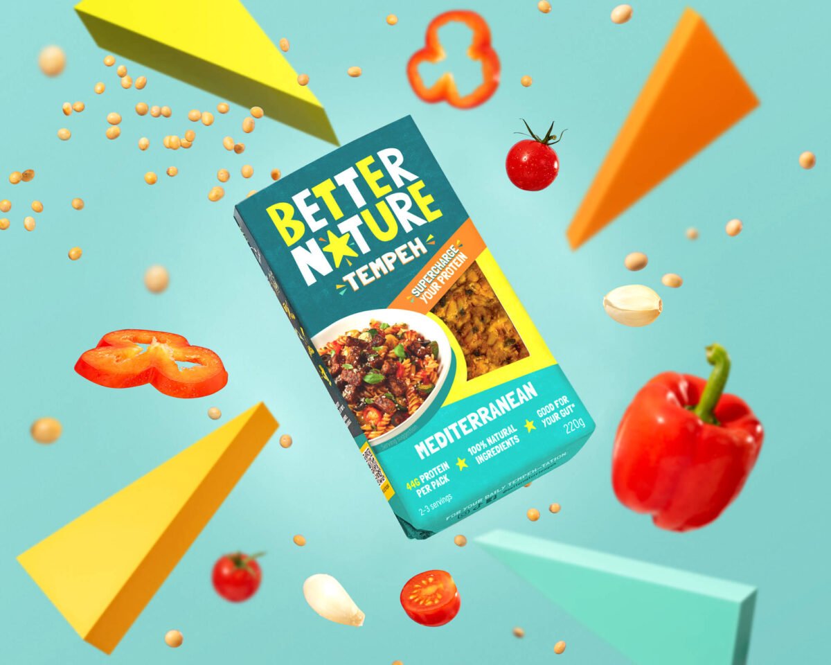 Image shows a pack of Better Nature's new mediterranean tempeh block against a blue background surrounded by digital depictions of vegetables