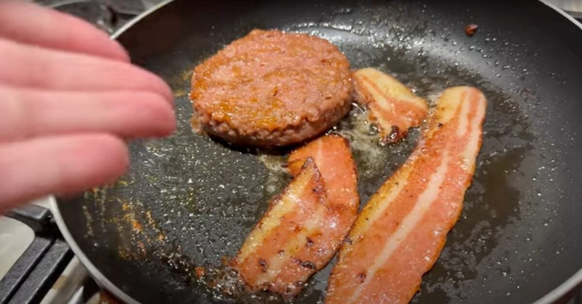 A Beyond Meat burger and vegan bacon in a frying pan