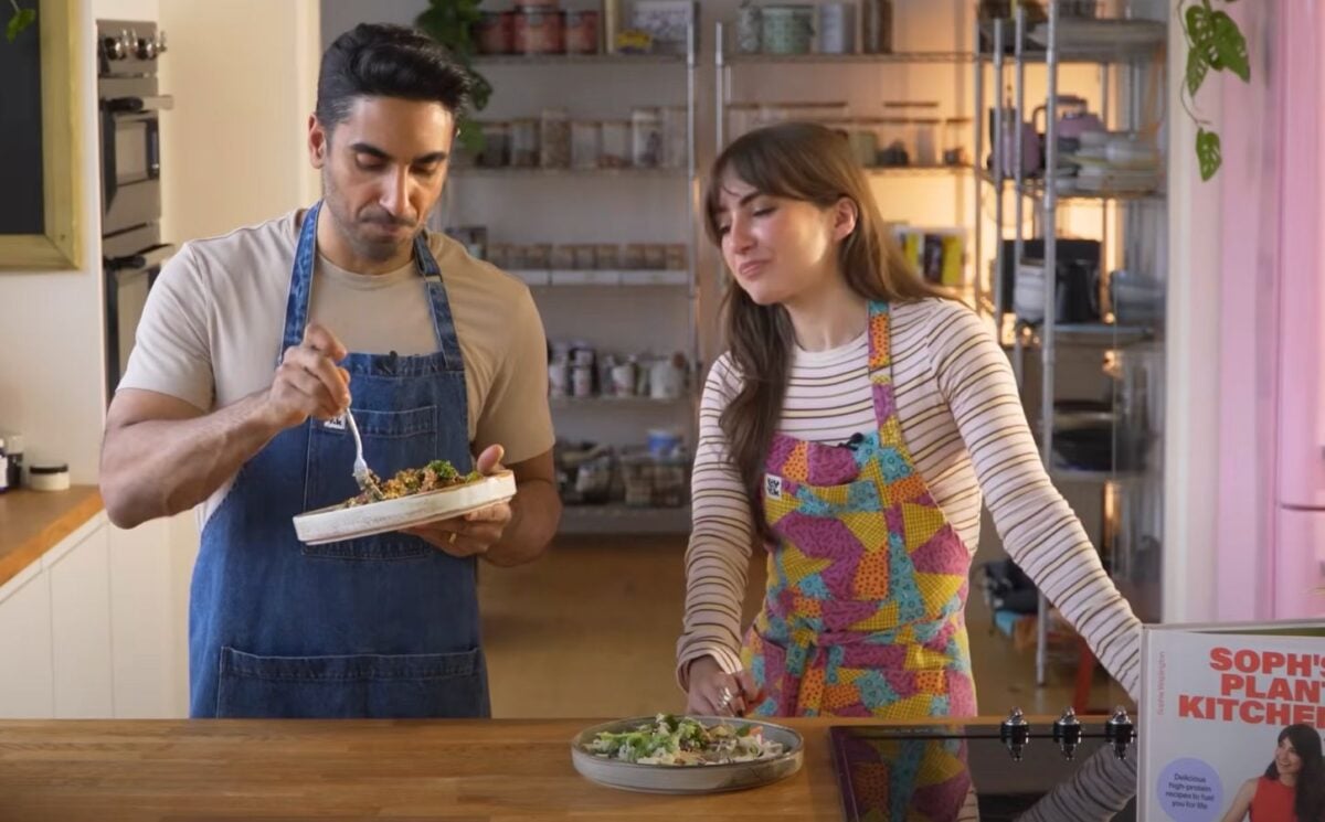 Dr. Rupy Aujla and Sophie Waplington stand by a counter cooking high-protein vegan work lunches