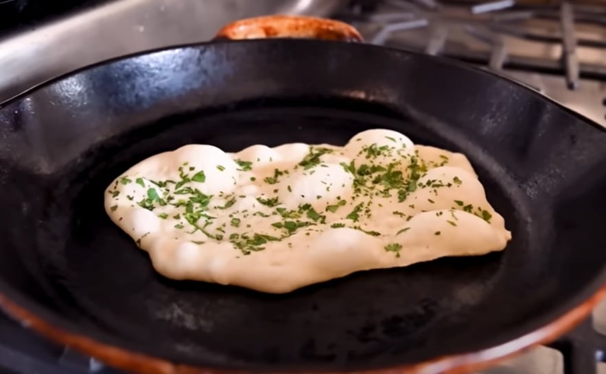 A vegan naan cooking in the frying pan