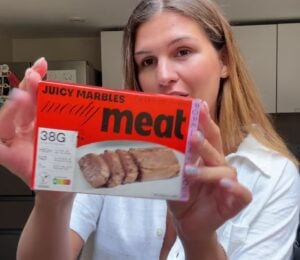 Vegan content creator Nicole Whittle holding up a pack of Juicy Marbles pork