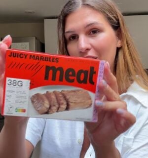 Vegan content creator Nicole Whittle holding up a pack of Juicy Marbles pork