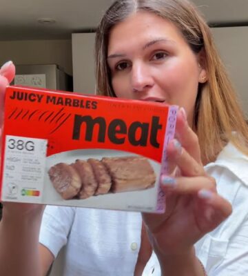 Vegan content creator Nicole Whittle holding up a pack of Juicy Marbles pork