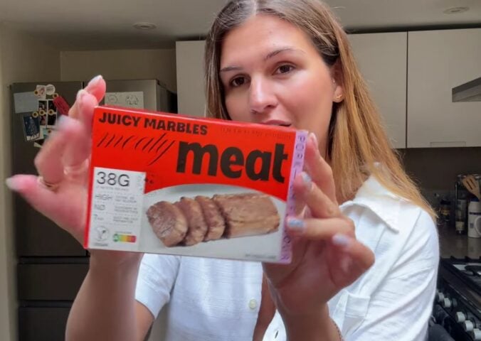Vegan content creator Nicole Whittle holding up a pack of Juicy Marbles pork