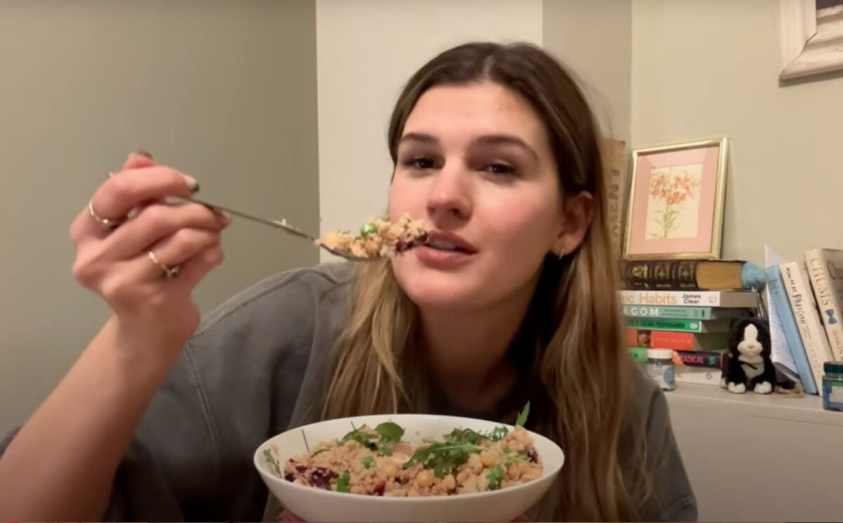 Nicole Whittle holds a colorful vegan couscous bowl packed with chickpeas, beetroot, and greens during her plant-based meal prep for the week.