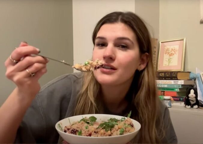 Nicole Whittle holds a colorful vegan couscous bowl packed with chickpeas, beetroot, and greens during her plant-based meal prep for the week.