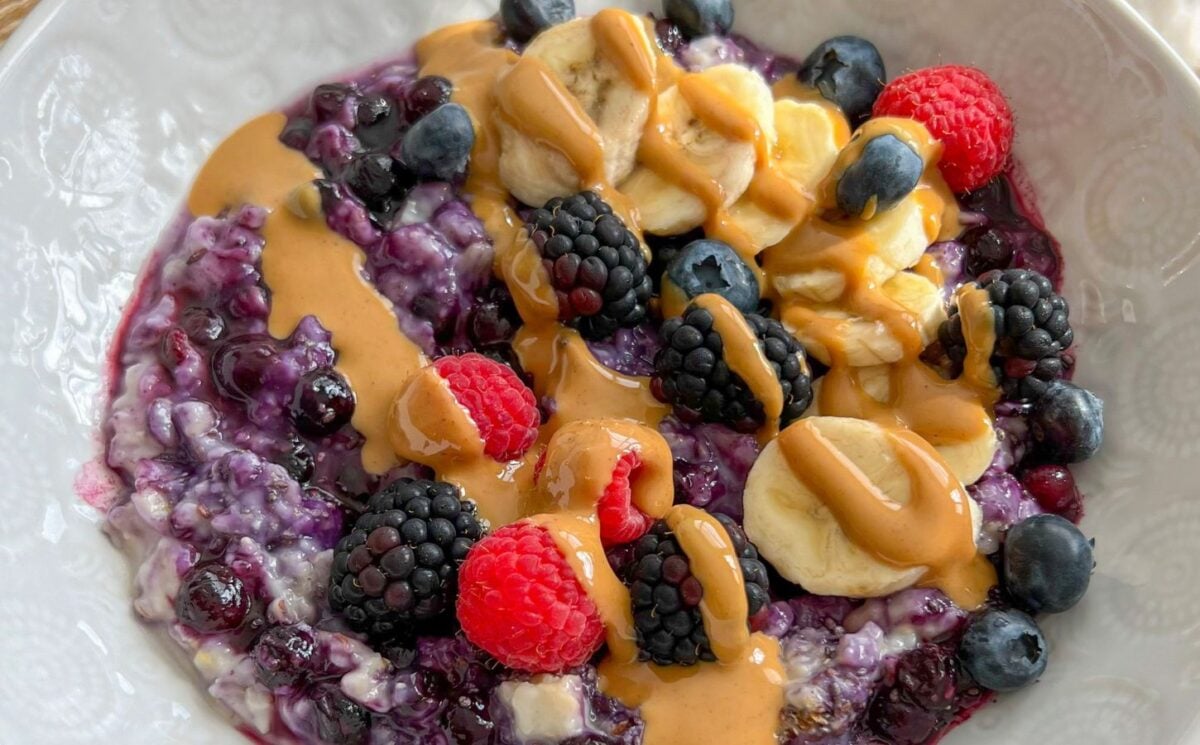 a bowl of 5-minute blueberry superfood oats with banana, nut butter, mixed berries, and chia seeds for vegan summer breakfast