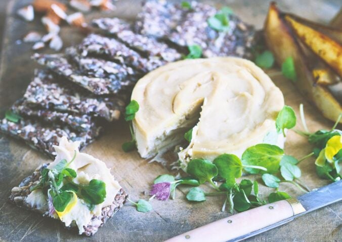 a board of truffled cashew cheese and caramelized pears with seed crackers