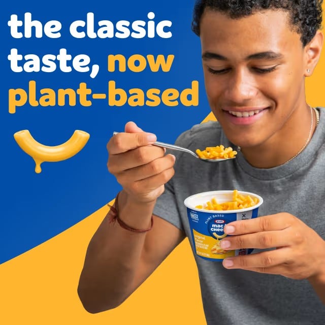 Photo shows a young man eating vegan mac and cheese out of a cup against a blue and yellow background, with text that reads: "The classic taste, now plant-based."