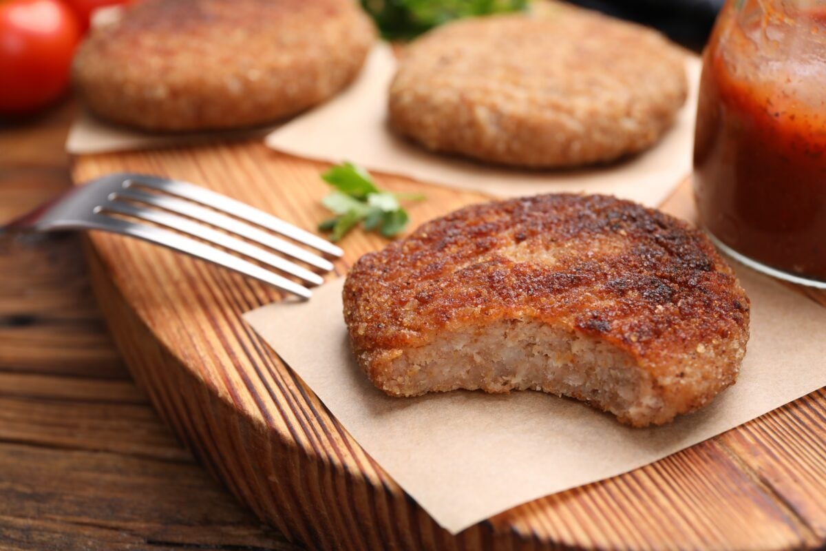 Photo shows a plant-based burger on a napkin with a bite out of it