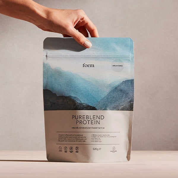 Photo shows a packet of Form's Pureblend Protein as someone's hand reaches for it