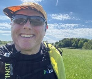 Photo is a selfie taken by vegan runner Bob Yates on a sunny day in a grassy field