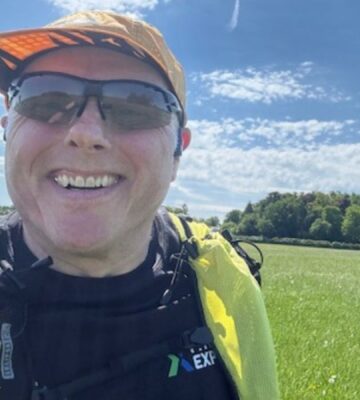 Photo is a selfie taken by vegan runner Bob Yates on a sunny day in a grassy field