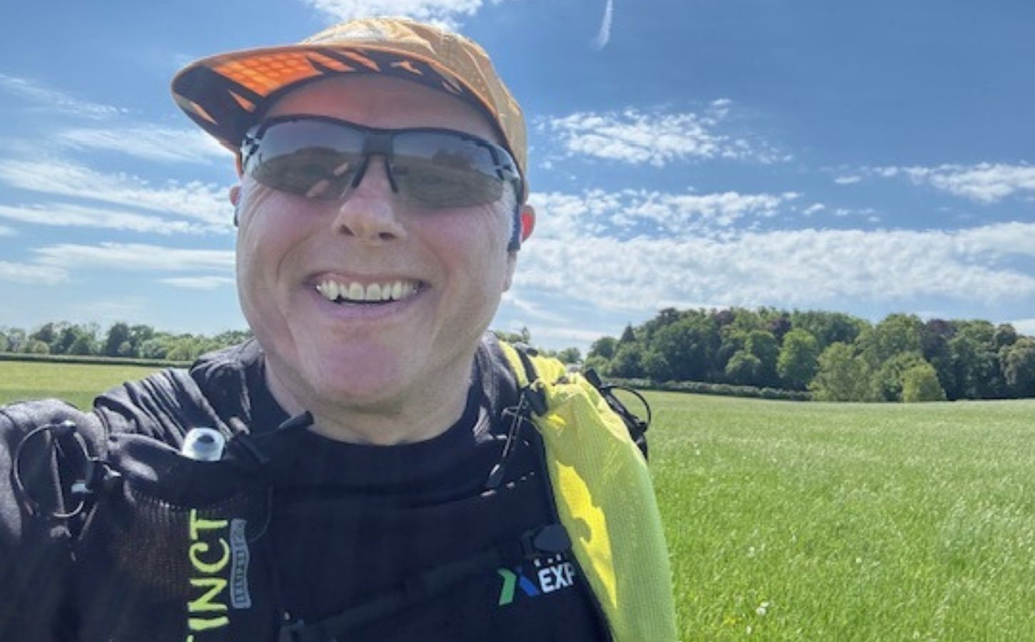 Photo is a selfie taken by vegan runner Bob Yates on a sunny day in a grassy field
