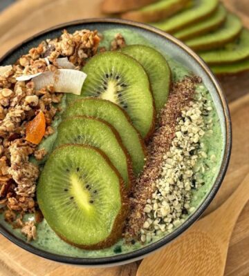 A green smoothie bowl with fruit and granola for vegan smoothie bowl breakfasts