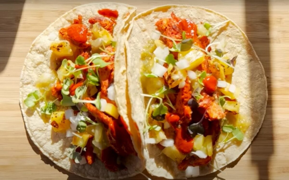 Two vegan tacos on a wooden chopping board