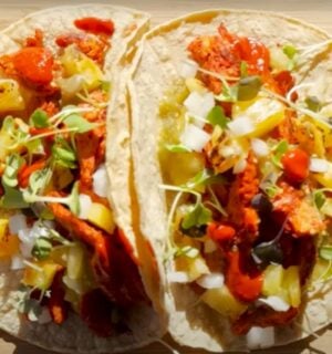 Two vegan tacos on a wooden chopping board
