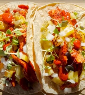 Two vegan tacos on a wooden chopping board